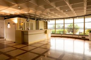 a large room with a lobby with a counter and windows at Hotel Cangrande Di Soave in Soave