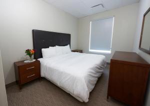 a bedroom with a large white bed and a window at Wasaga Riverdocks Hotel Suites in Wasaga Beach
