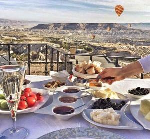 una mesa con platos de comida en una mesa con vistas en La Casa Cave Hotel, en Uchisar