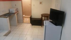 a kitchen with a television on top of a refrigerator at Pousada da Vivi in Porto De Galinhas