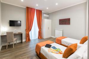 um quarto de hotel com duas camas e uma secretária em Dante Maison de Charme em Nápoles