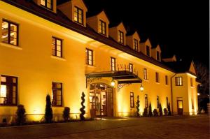 a large yellow building at night with lights at Turówka Hotel & Spa in Wieliczka