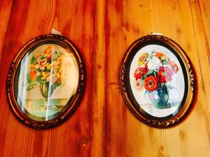 two pictures of flowers in vases on a wall at Auberge de l'Assesseur - Mont-Soleil in Saint-Imier