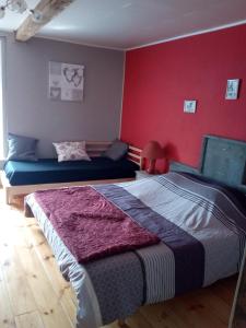 a bedroom with two beds and a red wall at Le Relais du Moulin in Gedinne