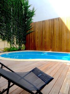 LOFT luxe hyper centre: terrasse/piscine/ salle de sport في بوردو: كرسي جالس على سطح بجانب مسبح