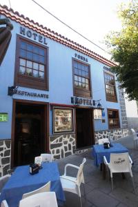 a blue building with tables and chairs in front of it at Fonda Central in Adeje