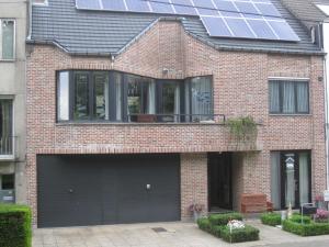 a house with a garage with solar panels on it at aan de vaart in Mechelen