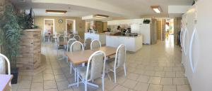 une cuisine et une salle à manger avec une table et des chaises dans l'établissement Western Budget Motel #3 Whitecourt, à Whitecourt