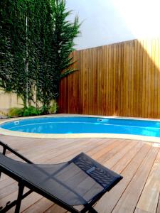 une chaise assise sur une terrasse à côté d'une piscine dans l'établissement T2 bis luxe hyper centre piscine, à Bordeaux