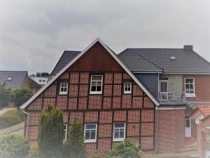 ein rotes Backsteinhaus mit schwarzem Dach in der Unterkunft Gästehaus Thuine in Thuine