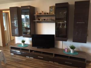 a living room with a entertainment center with a tv on it at Ferienwohnung Sobichowski in Rust