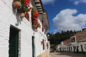 a white building with flowers on the side of it at Hotel Otti Colonial in Monguí