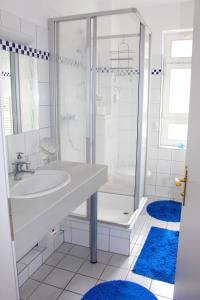biała łazienka z umywalką i prysznicem w obiekcie Ferienwohnung Villa Parkblick w mieście Oberhof