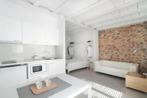 a kitchen with white cabinets and a brick wall at Estudio Casco Antiguo Inmomart in Peniscola