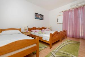 a bedroom with two beds and a window at Oreb Dream Apartments in Koločep