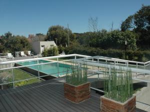 una piscina en la parte superior de una casa con terraza en La Medusa Valeria en Valeria del Mar