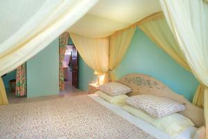 a bedroom with a canopy bed with two pillows at Royal Palm Holiday Apartment in Méro
