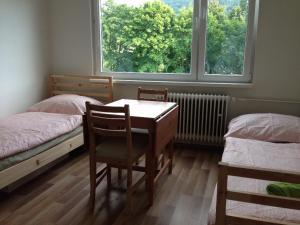 ヘイニツェにあるByt 1+kk, Hejniceのベッド2台、テーブル、椅子が備わる客室です。