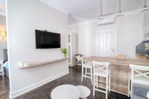 a living room with a table and a tv on a wall at Sweet 16 Studio in Ljubljana