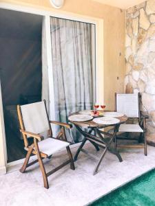 a table and chairs on a patio with a window at Apart Hotel Eden in Golden Sands