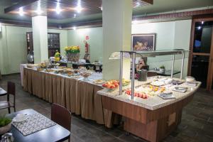 a buffet line with food on it in a restaurant at Hotel Veredas in Paracatu