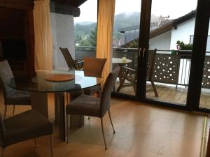 a dining room with a table and chairs and a balcony at Haus am Waldrand in Birkenhördt +15 photos
