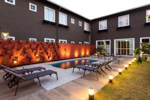 a building with a pool and tables and chairs at Pousada Armazém 26 in Tiradentes