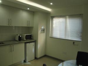 a small kitchen with a microwave and a window at Apto T1 Comfort in Praia