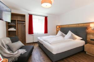 a bedroom with a large bed and a chair at Chalet Grossglockner in Fusch an der Glocknerstraße