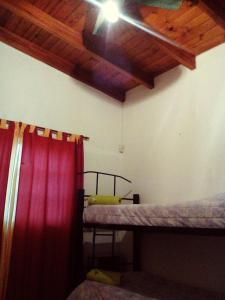 a room with two bunk beds with a red curtain at Cabañas Aliksir in Cosquín