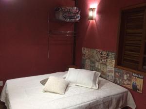 a bedroom with a bed with two white pillows at Pousada Evolucao in Macacos