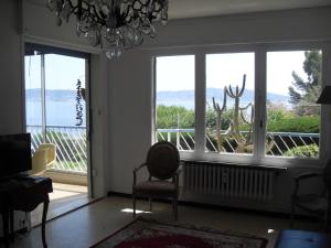 a living room with large windows and a chandelier at Appartement Residence le Cap Toulon in Toulon