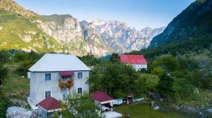 an aerial view of a house with mountains in the background at Guesthouse Marashi in Theth