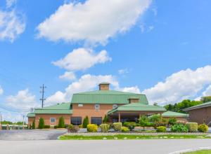古德雷特維爾的住宿－Americas Best Value Inn - Goodlettsville，一座带绿色屋顶的大型建筑和一个停车场