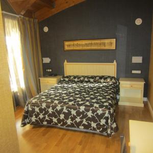 a bedroom with a bed with a black and white comforter at Hotel Iru-Bide in Lumbier