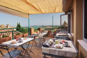 eine Gruppe von Tischen und Stühlen auf einem Balkon in der Unterkunft La Bellavita B&B in Pienza