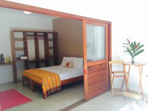 a bedroom with a canopy bed and a table at Moksha Surf Yoga in Ubatuba