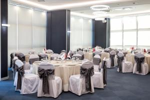 una habitación llena de mesas y sillas con manteles blancos en Ramada Hotel by Wyndham Edirne, en Edirne
