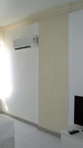Habitación con una pared blanca y aire acondicionado. en Studio na praia da Barra, en Salvador