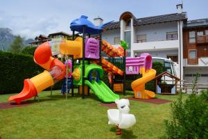 um parque infantil com escorrega e um pato insuflável em Hotel Abete Bianco em Andalo