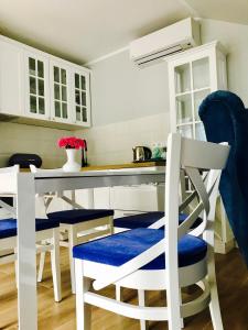 a kitchen with white cabinets and blue chairs and a table at Apartamenty Platinum in Łukęcin