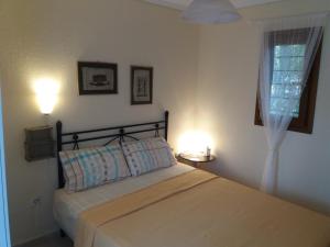 a bedroom with a bed with two lamps and a window at Evgenia Maisonette in Ierissos