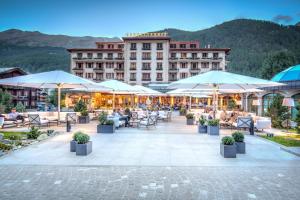 un hôtel avec une terrasse dotée de tables et de parasols dans l'établissement Grand Hotel Zermatterhof, à Zermatt