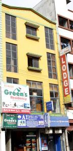 żółty budynek z znakami przed nim w obiekcie Greens Residency w mieście Bengaluru