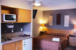 een hotelkamer met een bed en een wastafel bij Kiwi Studios Motel in Palmerston North