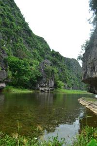 un río entre dos montañas con vegetación verde en Tam Coc Smile Homestay, en Ninh Binh