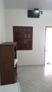 a room with a wooden cabinet and a white wall at Chalé da Selma I (Isaías) in Alto Paraíso de Goiás