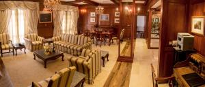 a living room with couches and a dining room at Mahaweli Reach Hotel in Kandy