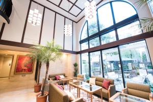 a lobby with chairs and tables and windows at Hotel Rose Garden Shinjuku in Tokyo