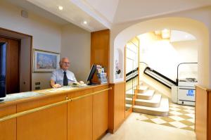 a man sitting at a counter in a waiting room at Hotel Tex in Rome